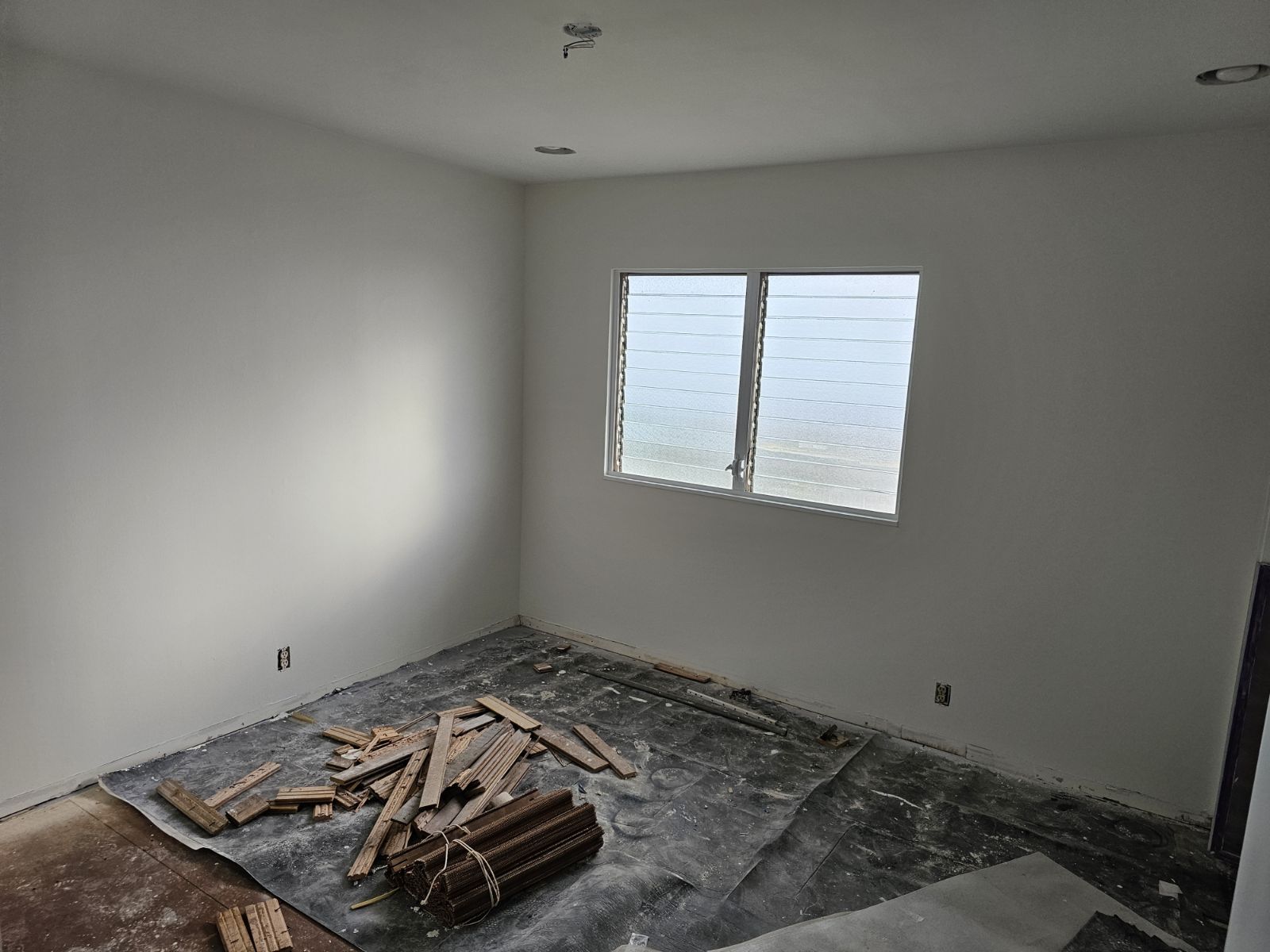 A room with a lot of wood on the floor and a window.
