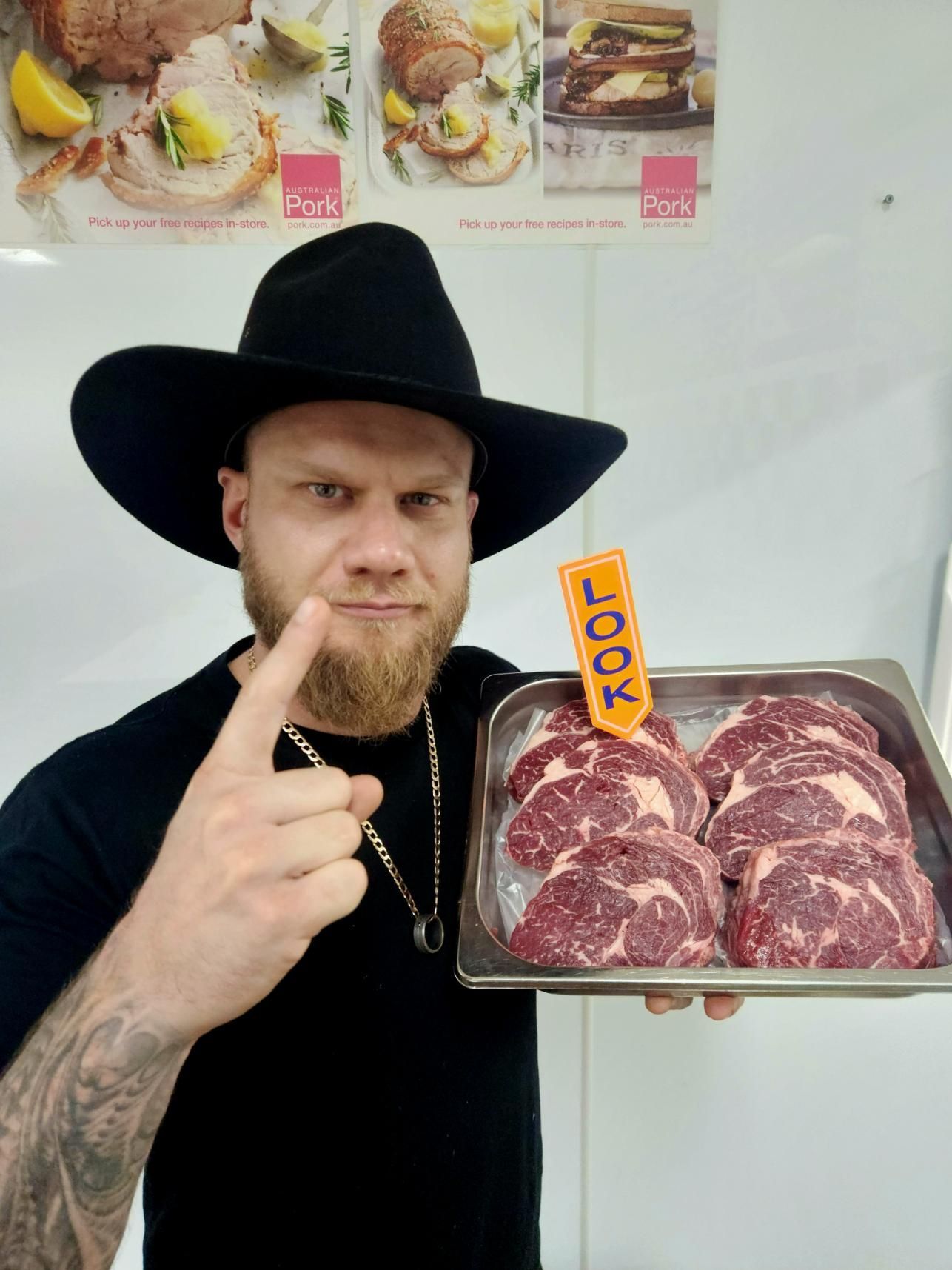 A Man in a Cowboy Hat is Holding a Tray of Meat — Multy Cut Meats In Yorkeys Knob, QLD