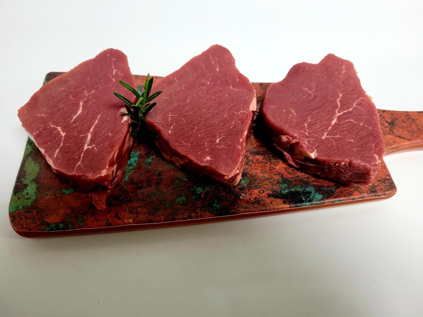 Three Steaks Are Sitting on a Wooden Cutting Board — Multy Cut Meats In Yorkeys Knob, QLD
