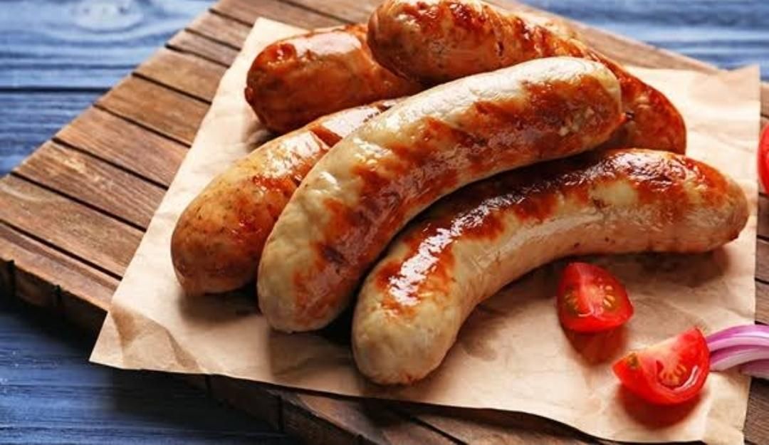 A Bunch of Sausages Are Sitting on a Piece of Paper on a Wooden Cutting Board — Multy Cut Meats In Yorkeys Knob, QLD