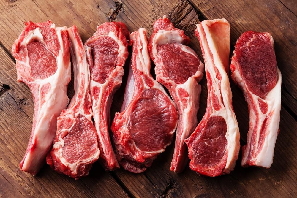 Raw Lamb Chops Are Arranged in a Row on a Wooden Table — Multy Cut Meats In Smithfield, QLD
