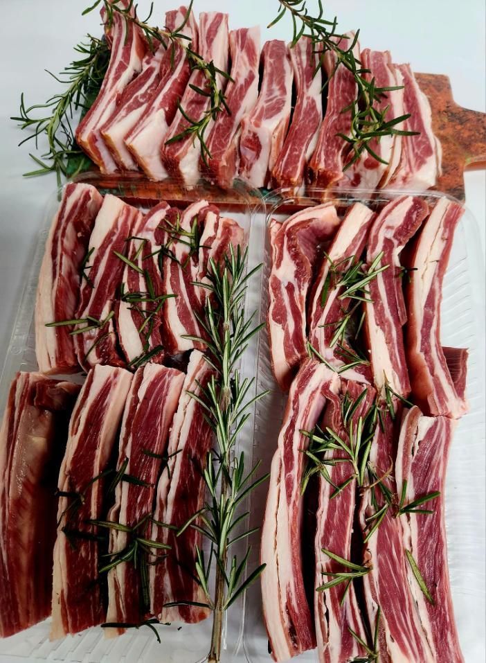 A Bunch of Meat is Sitting on a Table With Rosemary — Multy Cut Meats In Yorkeys Knob, QLD