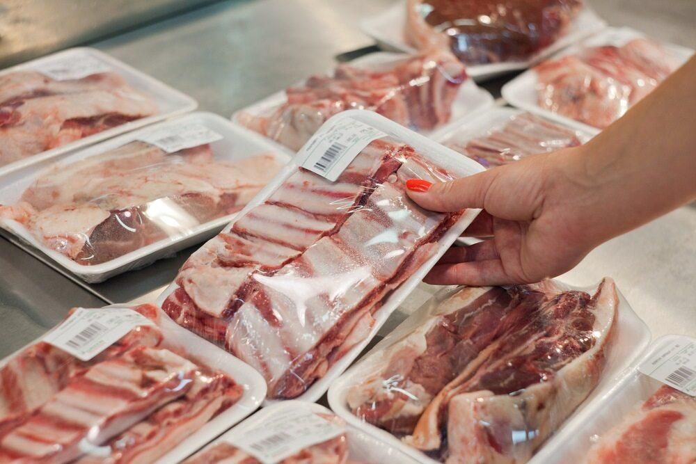 A Person is Holding a Tray of Meat in a Store — Multy Cut Meats In Yorkeys Knob, QLD