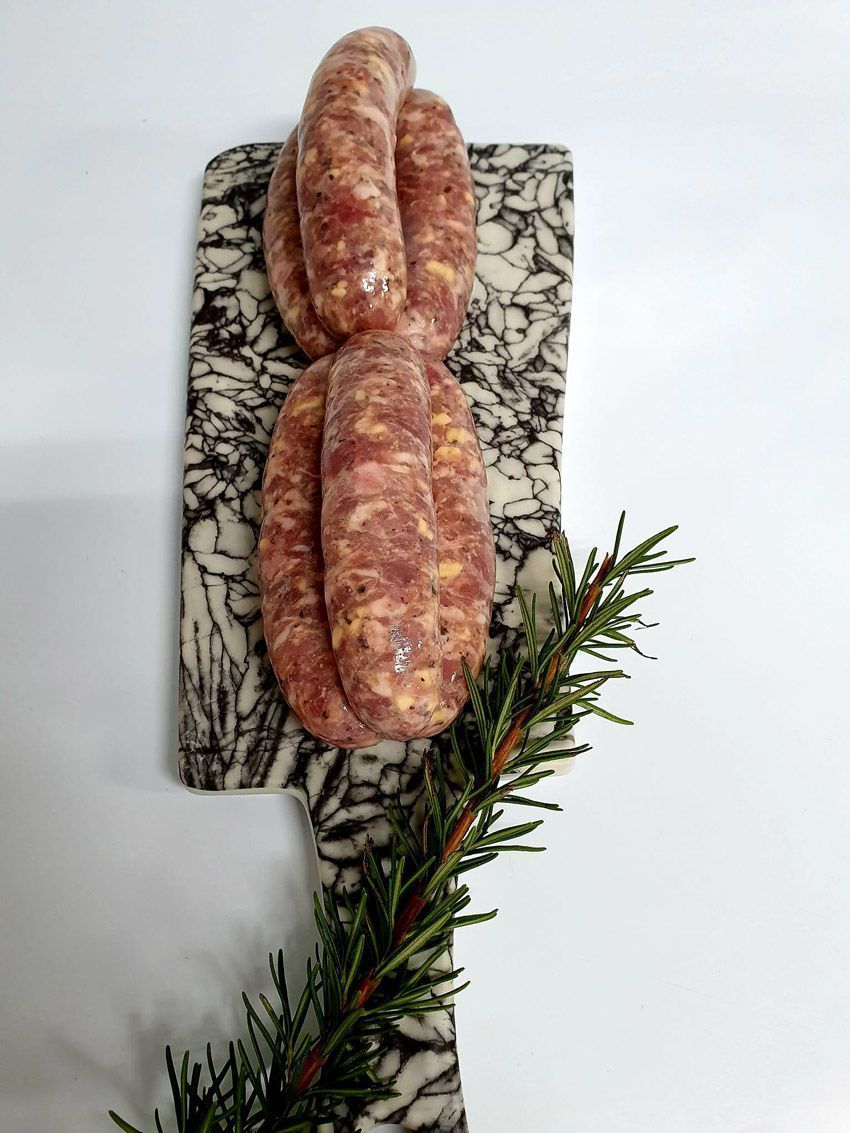 Three Sausages Are Sitting on a Cutting Board With a Sprig of Rosemary — Multy Cut Meats In Yorkeys Knob, QLD
