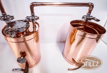 Two copper pots with a stillz logo on them