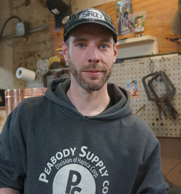 A man wearing a peabody supply co hoodie
