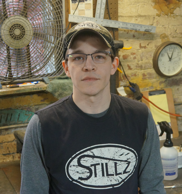 A man wearing a black shirt that says stillz