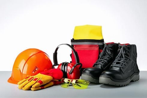 Un casco, guantes, orejeras, botas y otros equipos de seguridad están sobre una mesa.