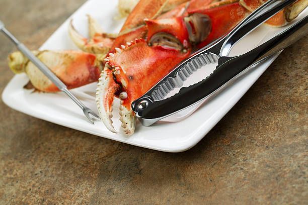 A White Plate Topped With Crab Claws And A Cracker — Conway, SC — Graham Seafood Supplies Inc.
