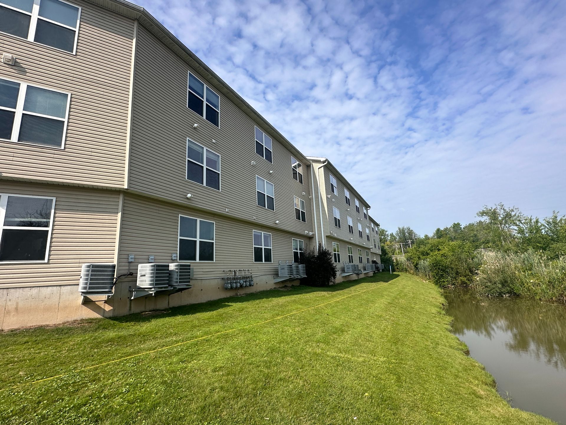 A large building with a lot of windows is next to a body of water.