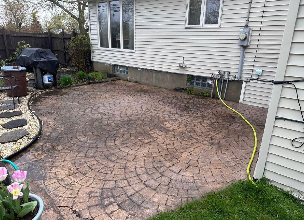 A hose is connected to a patio in front of a house.