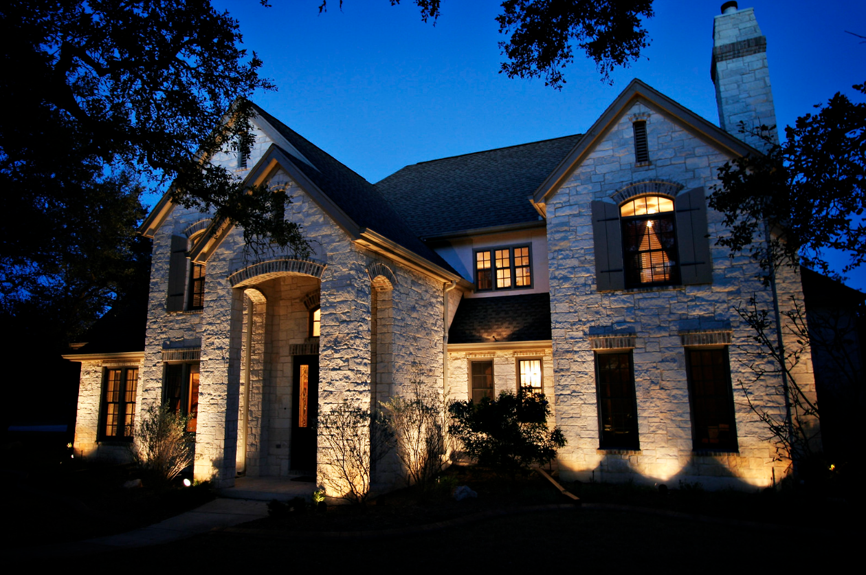 A large brick house is lit up at night