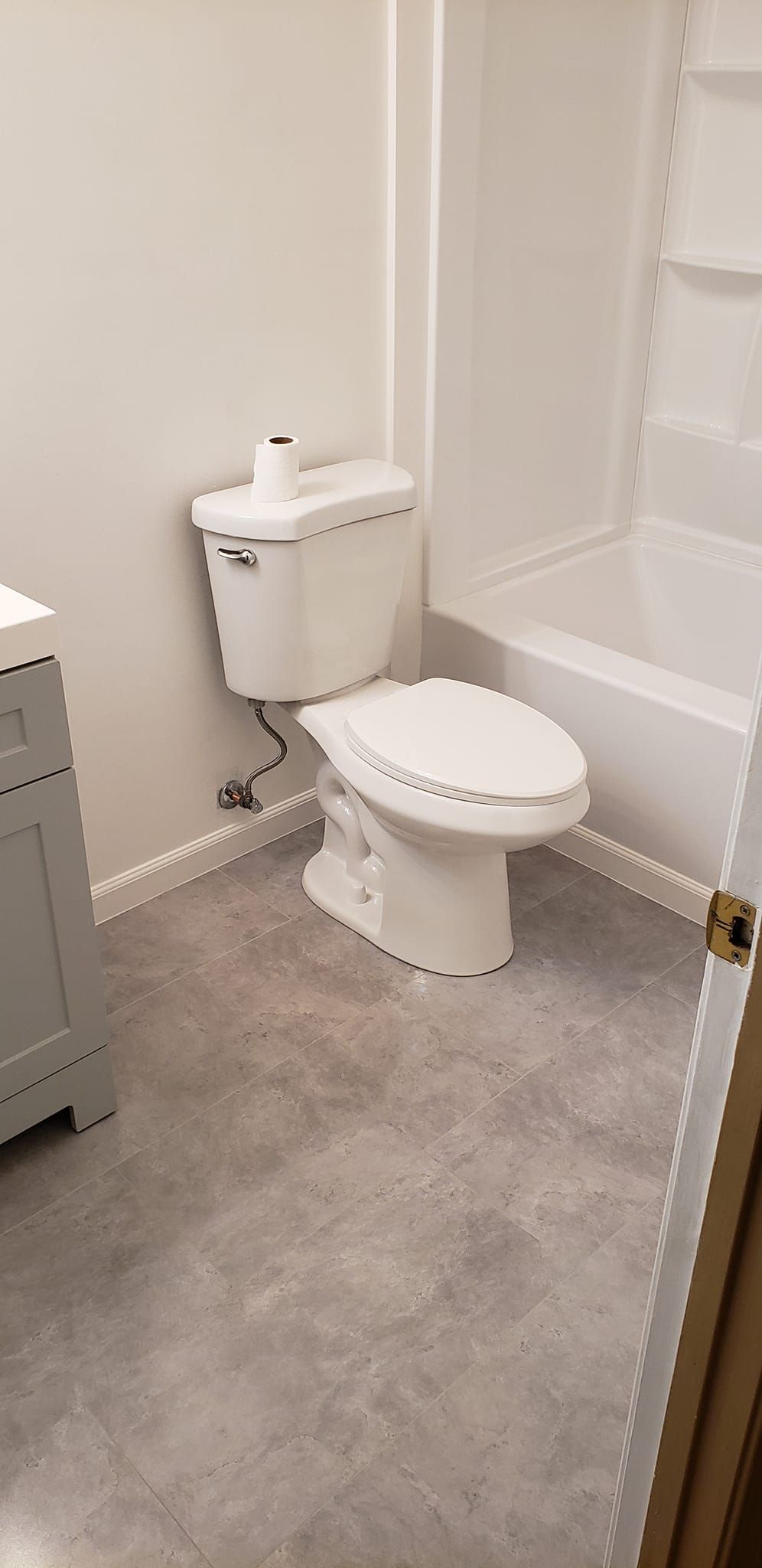 A bathroom with a toilet , sink , and bathtub.