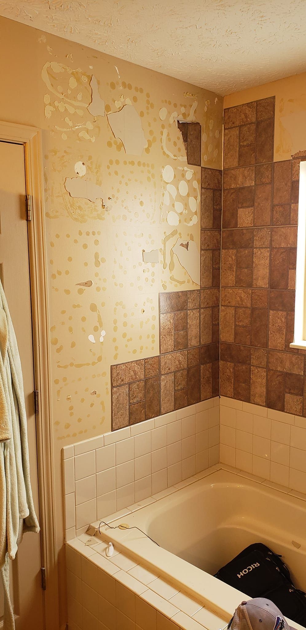 A bathroom with a bathtub and a window.