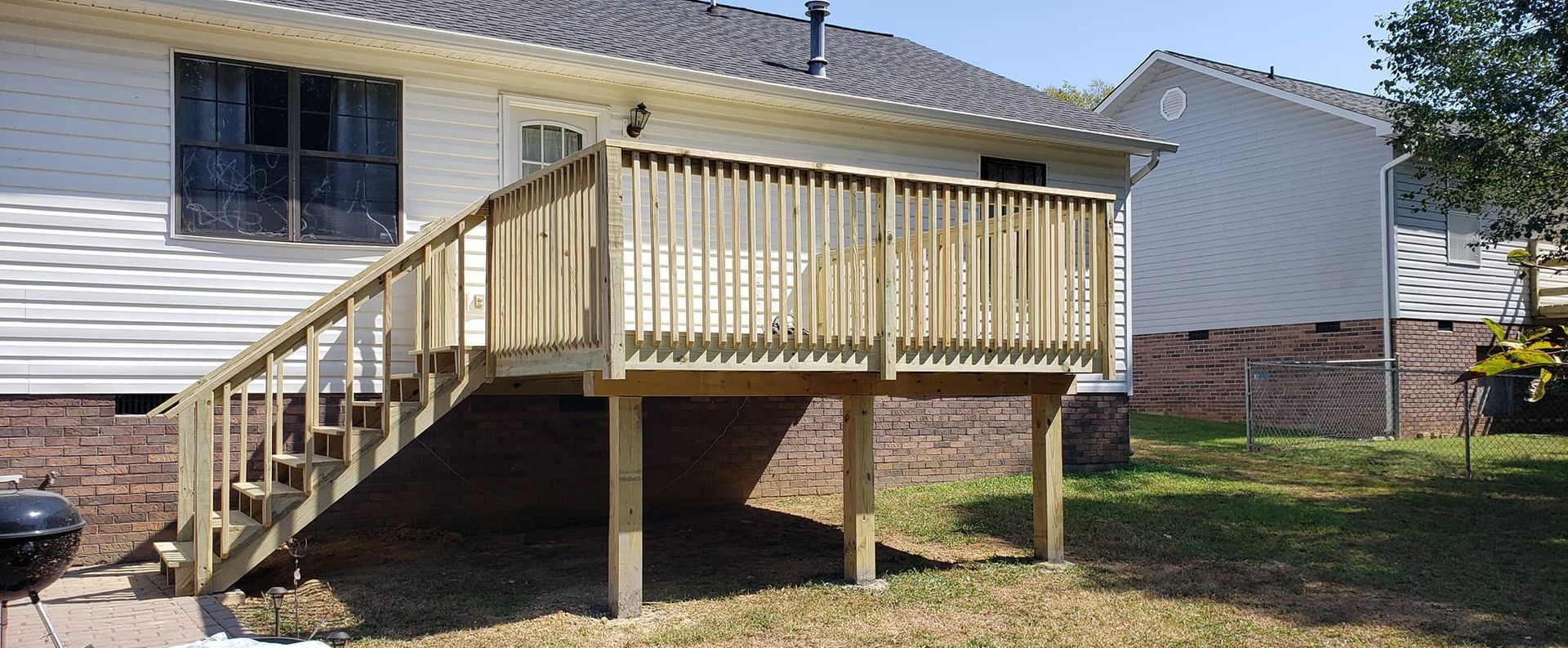 A white house with a wooden deck in front of it