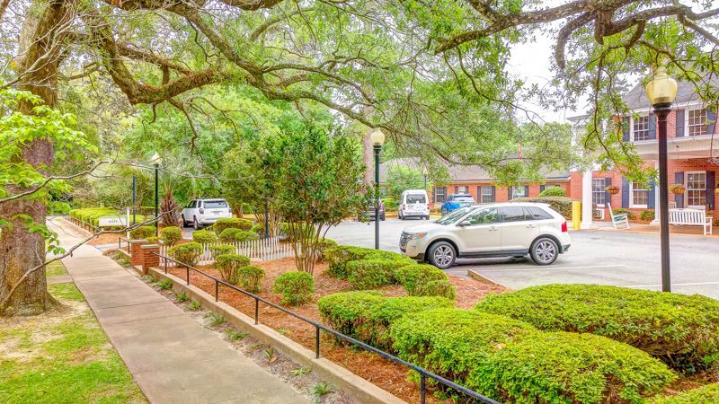 A white suv is parked in a parking lot next to a sidewalk.