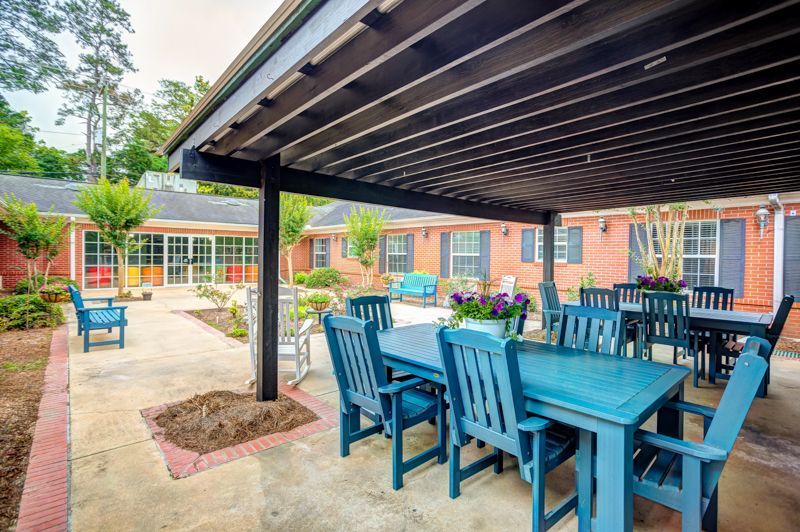 A patio with a table and chairs under a pergola.