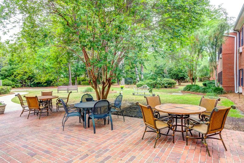 There are many tables and chairs on the patio.