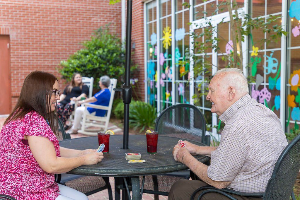 A man and a woman are sitting at a table talking to each other.