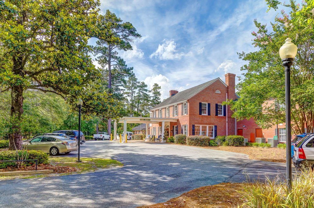 A large brick building with a lot of cars parked in front of it.