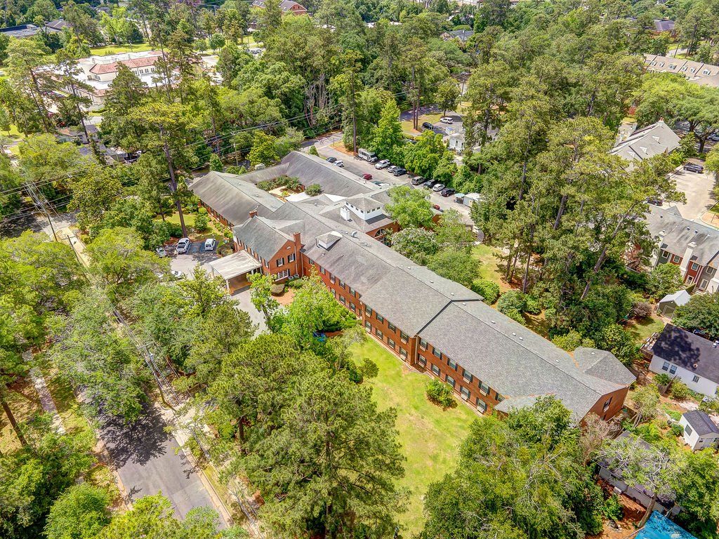 An aerial view of a large brick building surrounded by trees.