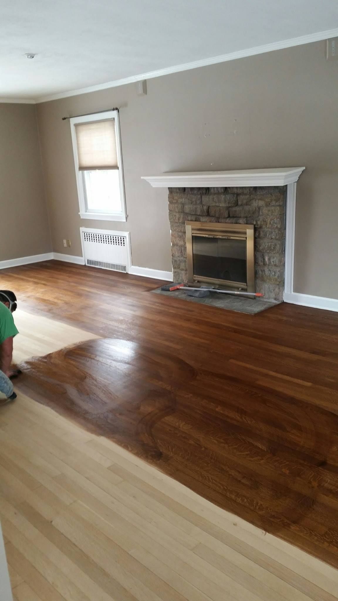 A living room with hardwood floors and a fireplace.