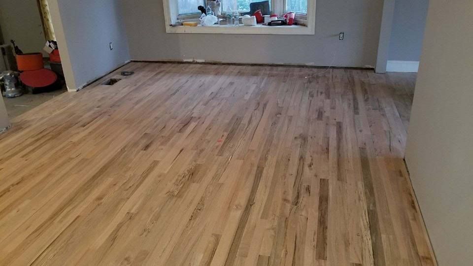 A living room with a wooden floor and a window.