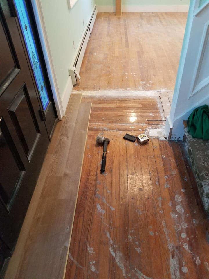 A wooden floor with a hammer and brush on it.