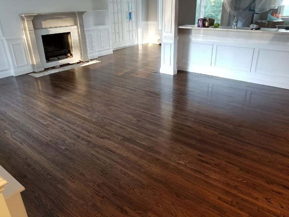 Dark stained hardwood floors in a room with white wainscoting, a fireplace, and a counter.