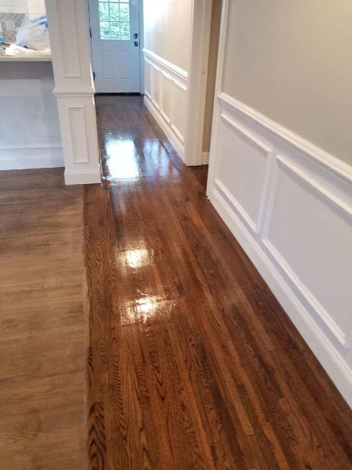A hallway with hardwood floors and white trim in a house.