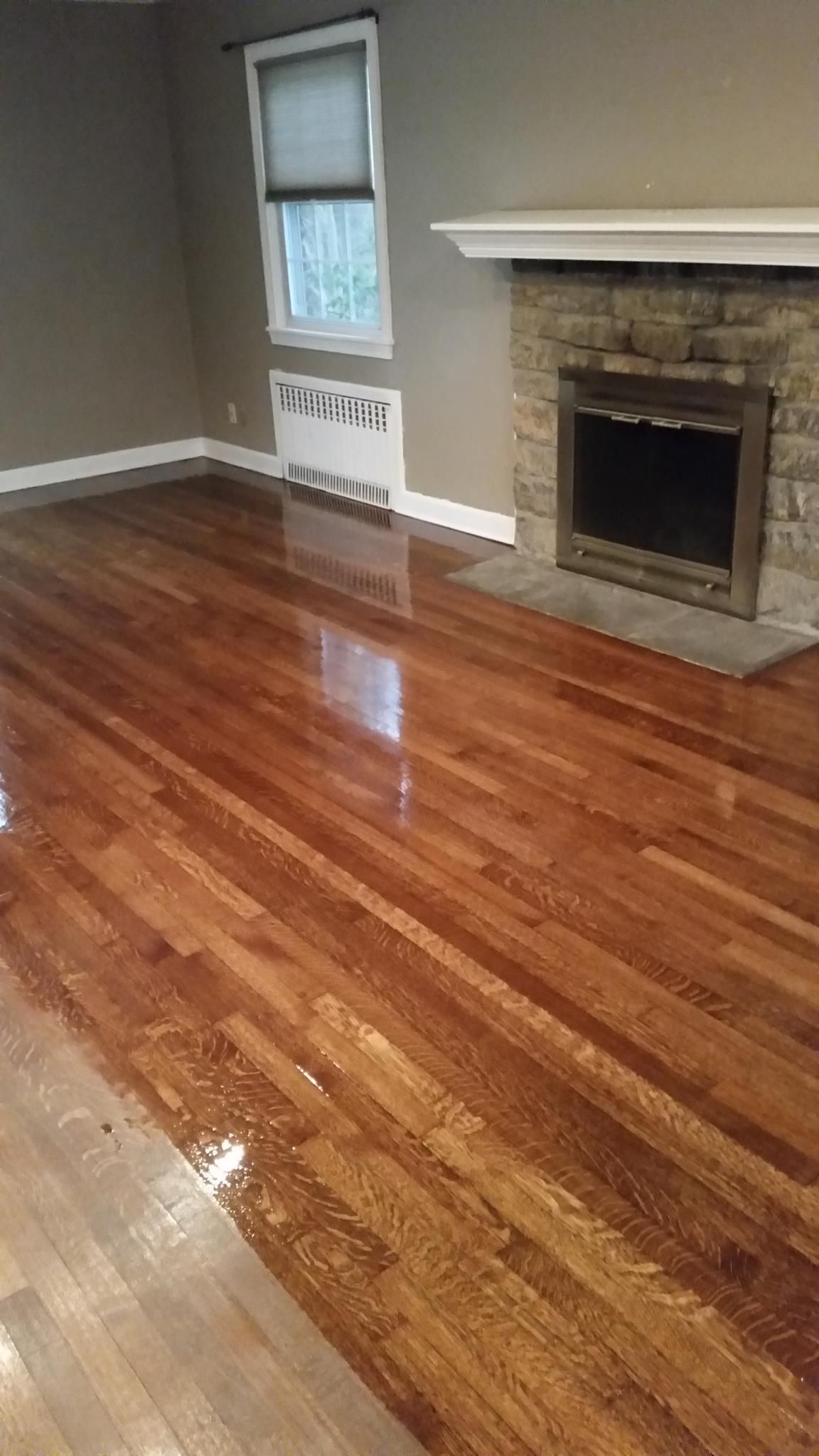 A living room with hardwood floors and a fireplace.