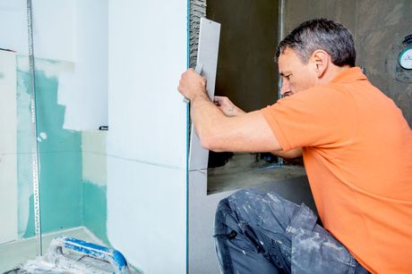 The tiler works in the bathroom of a modern house