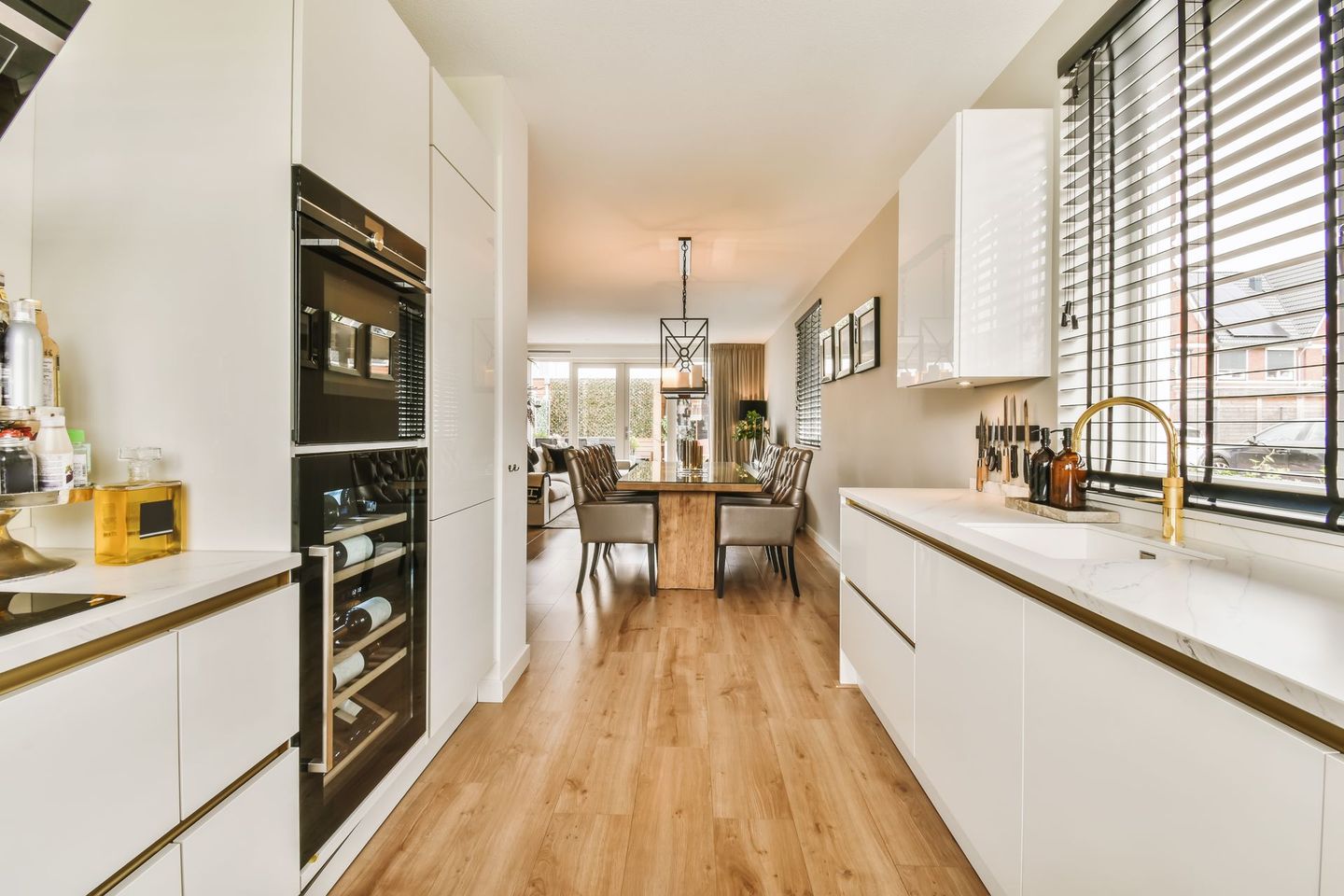 A kitchen with wood flooring and white cabinets in the middle of the room