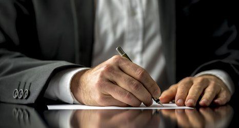 man signing an official document 