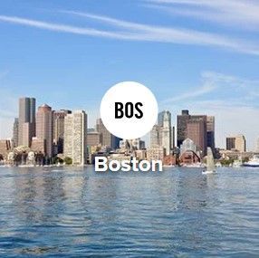 Boston skyline with "BOS" in a white circle over the city. Sunny day, water in foreground.