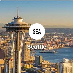 Space Needle in Seattle with "SEA" label. City skyline with harbor in background.