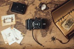An old camera is sitting on top of an old map.