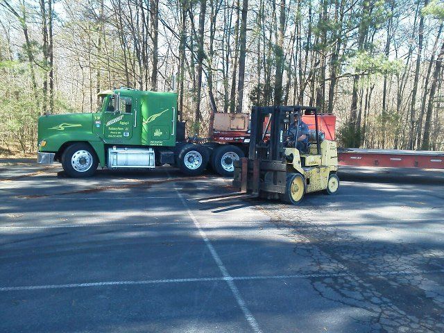 Industrial Moving Company — Forklift Truck in Side of Long Green Truck in Monroe, NC