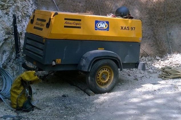 Compressore d'aria giallo e grigio montato su rimorchio, modello 