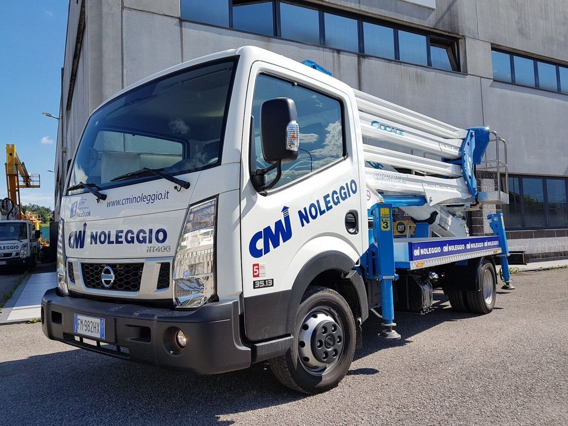 Camion Nissan bianco con sollevatore blu e scritta 