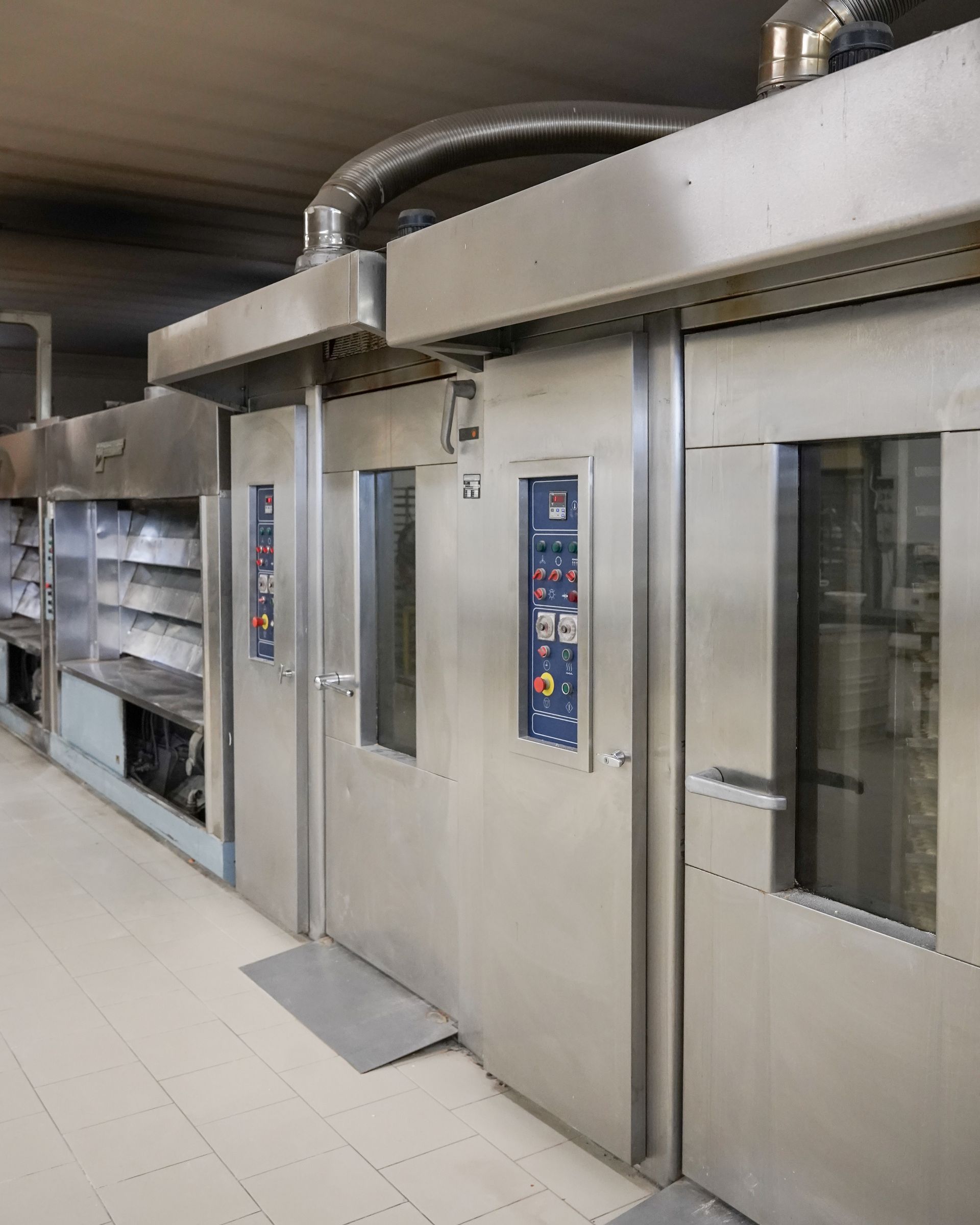 Forni industriali per panetteria in una cucina commerciale. Sportelli e pannelli di controllo in acciaio inox.