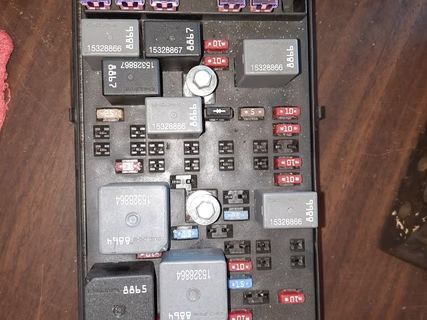 Black fuse box with numerous fuses and relays. | Lains Auto Service