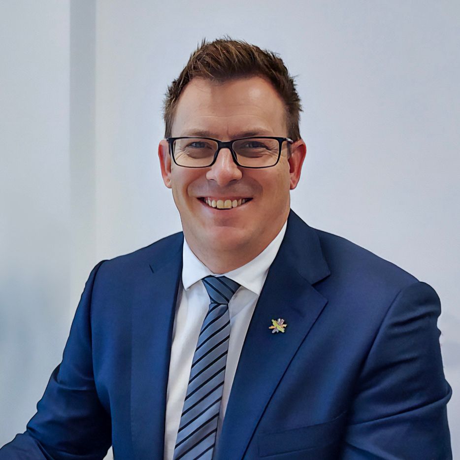 A man in a suit and tie is smiling for the camera