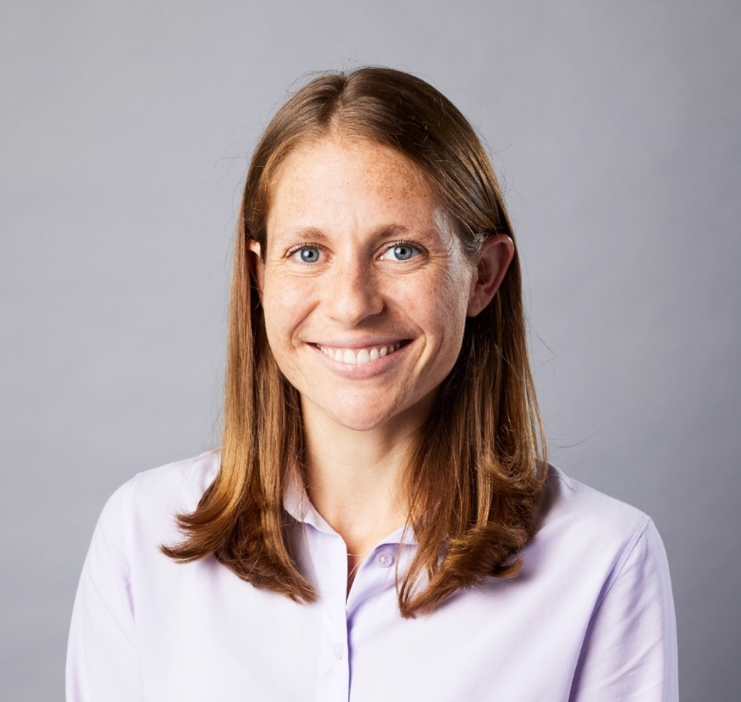 A woman in a purple shirt smiles for the camera