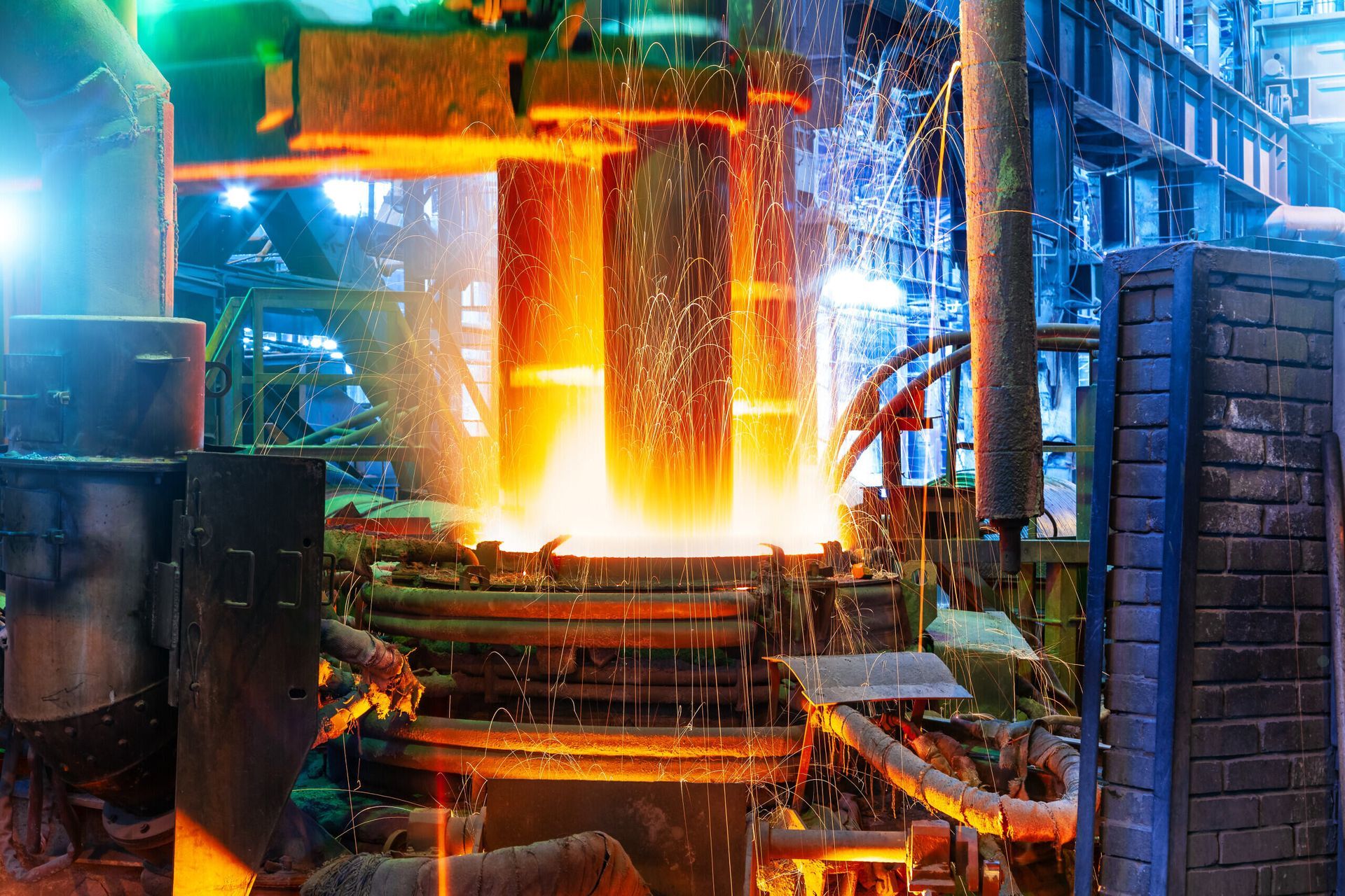 A factory with molten metal coming out of a furnace.