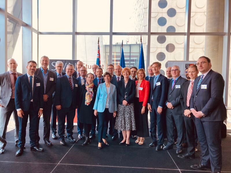 A group of people in suits and ties are posing for a picture.