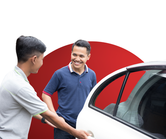Two men are standing next to a white car and smiling