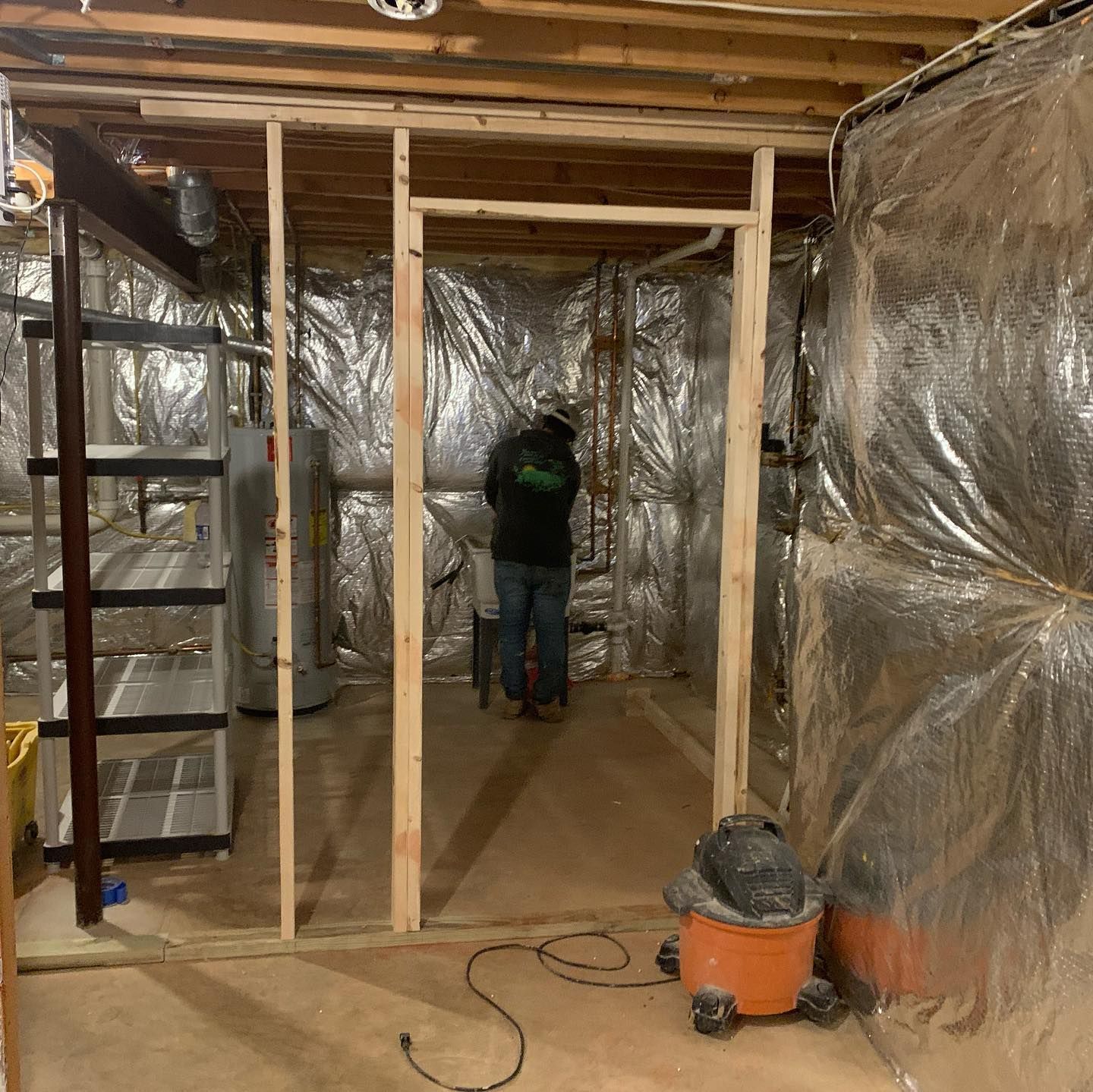 A man is standing in a room with a vacuum cleaner.