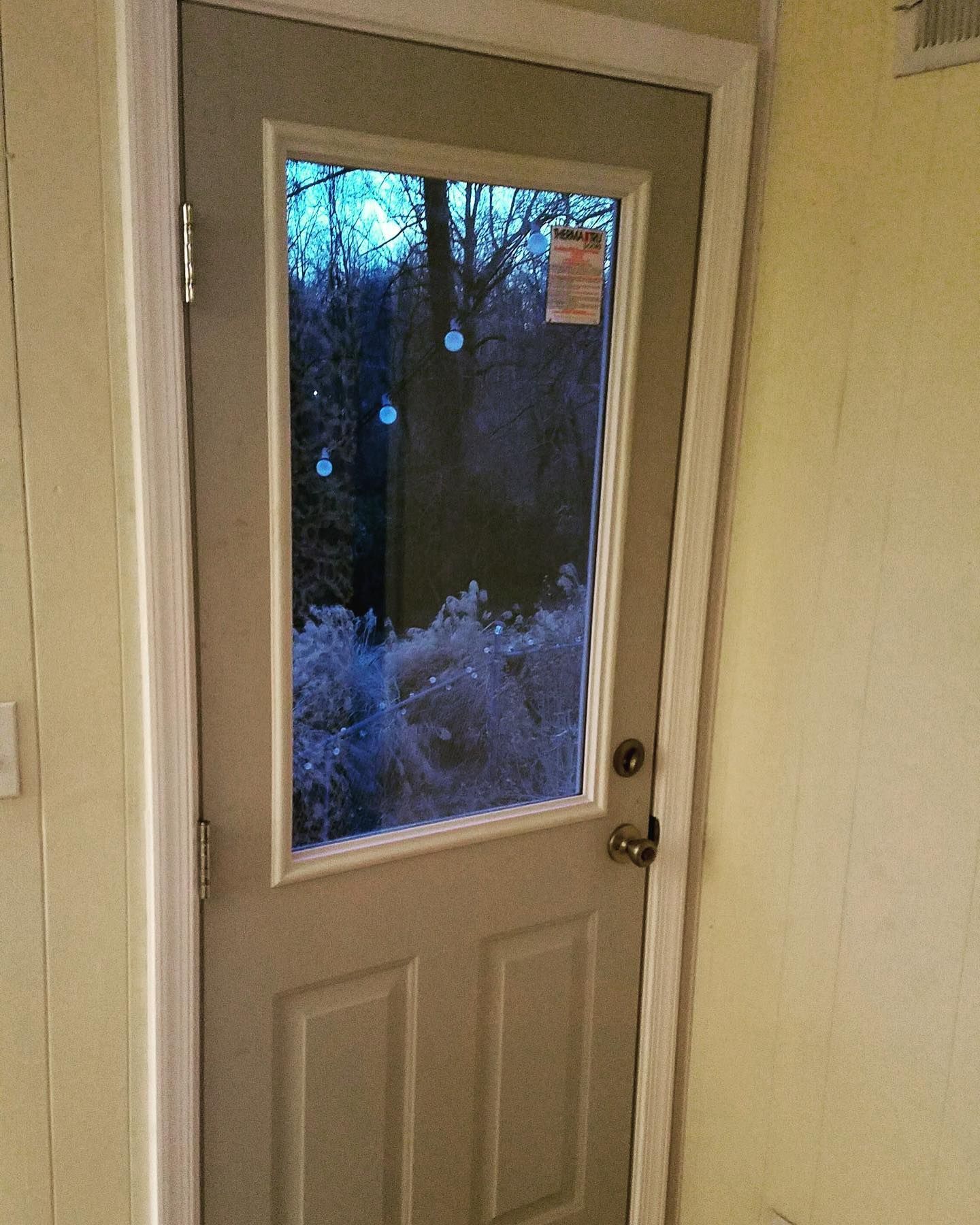 A door with a window and a sticker on it