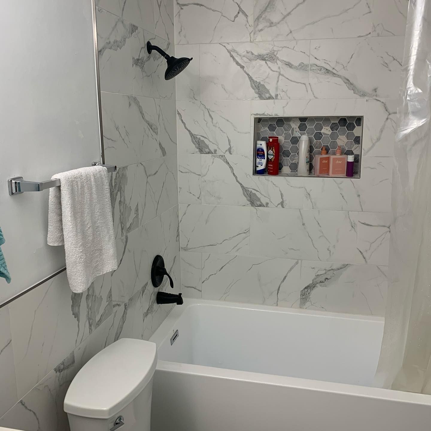 A bathroom with a toilet , bathtub and shower